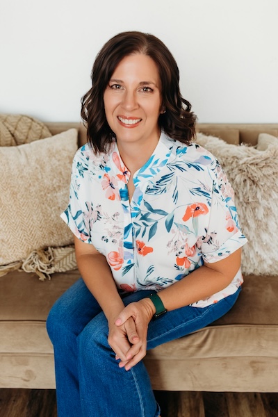 Smiling woman leaning slightly forward while sitting on couch