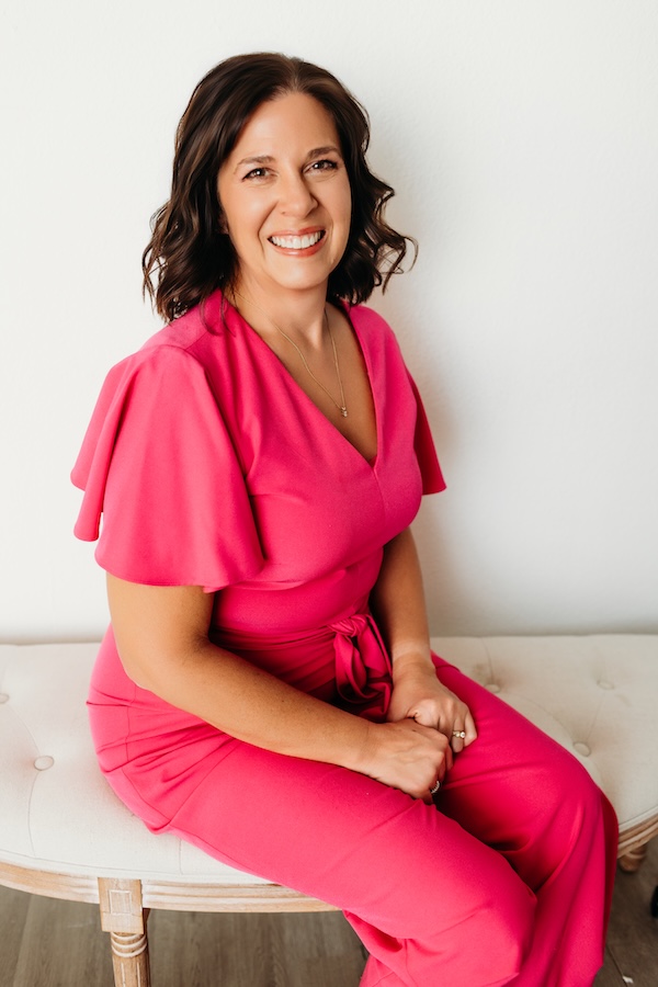 Smiling woman sitting on a bench in a living room.